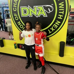 Two girls posing in front of a sign.
